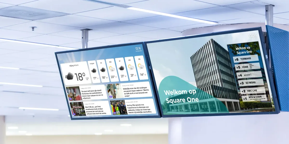 Two professional narrowcasting displays on the ceiling of an office lobby